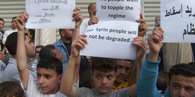 May 5, 2011: In this citizen journalism image made on a mobile phone and acquired by the AP, Syrians carry banners during a protest against the regime of President Assad, in the coastal town of Banias, Syria.