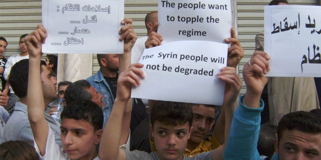 May 5, 2011: In this citizen journalism image made on a mobile phone and acquired by the AP, Syrians carry banners during a protest against the regime of President Assad, in the coastal town of Banias, Syria.