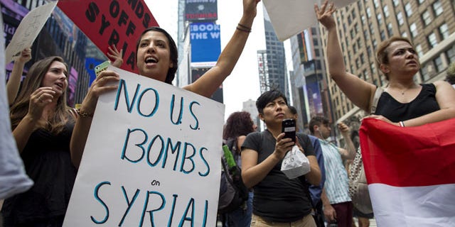 August 31, 2013: Rachel Lee Richards of New York. left, stands with opponents of a United States military strike against Syria as she and others protest at Times Square in New York