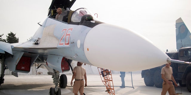 Oct. 22, 2015: Russian air force technicians service a Russian fighter jet at Hemeimeem airbase, Syria.