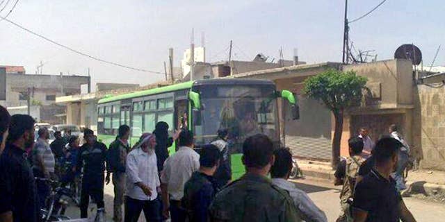 In this Wednesday, May 7, 2014 photo provided by the anti-government activist group Coordination Committee of Khalidiya Neighborhood in Homs, which has been authenticated based on its contents and other AP reporting, Free Syrian Army fighters board a bus leaving Homs, Syria. President Barack Obama may soon sign off on a project to train and equip moderate Syrian rebels, in an open move that would significantly boost U.S. support to forces who have been asking for three years for military help in their quest to oust President Bashar Assad, administration officials said Tuesday.The step, which could be announced as early as Wednesday, would send a limited number of American troops to Jordan to be part of a regional training mission that would instruct carefully vetted members of the Free Syrian Army on tactics, including counterterrorism operations, the officials said. They said Obama has not yet given final approval for the initiative, and that there is still internal discussion about its merits and potential risks. (AP Photo/The Coordination Committee of Khalidiya Neighborhood in Homs)