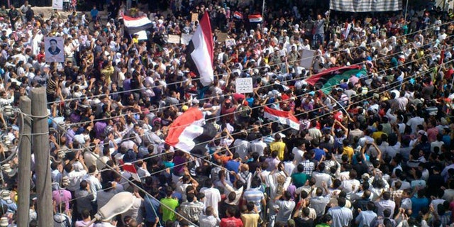 Anti-Syrian President Bashar Assad protesters, gather during a demonstration against the Syrian regime, at al-Hirak village, in Daraa province, Syria, on Friday, Sept. 30, 2011.