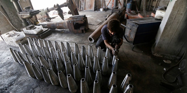 Sept. 9, 2014: A rebel fighter assembles mortar shells inside a weapons factory in the southern countryside of Idlib, Syria.