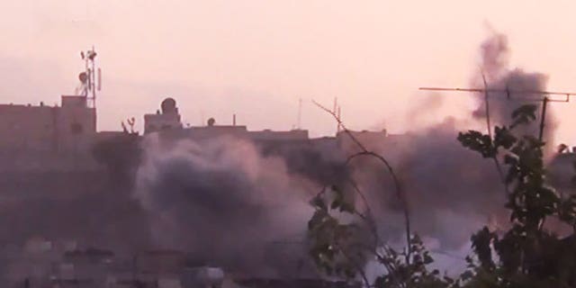 June 26, 2012: In this image made from amateur video released by the Shaam News Network smoke rises from buildings following purported shelling in Homs, Syria.