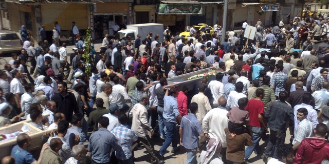May 21: In this citizen journalism image made on a mobile phone and acquired by the AP Syrian anti-government supporters carry the coffins of people whom they say were killed in the government crackdown, in the central city of Homs, Syria.
