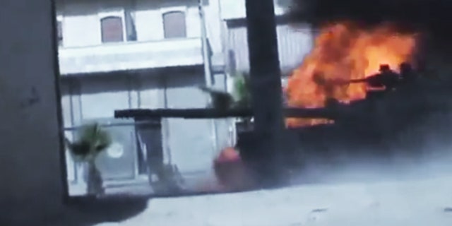 July 23, 2012: In this image made from amateur video released by the Ugarit News, Syrian government troops are seen on a military tank as it catches on fire during clashes with Free Syrian Army soldiers in Aleppo, Syria.