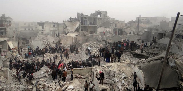 Feb. 19, 2013: This citizen journalism image provided by Aleppo Media Center AMC, which has been authenticated based on its contents and other AP reporting, shows people searching through the debris of destroyed buildings in the aftermath of a strike by Syrian government forces, in the neighborhood of Jabal Bedro, Aleppo, Syria.