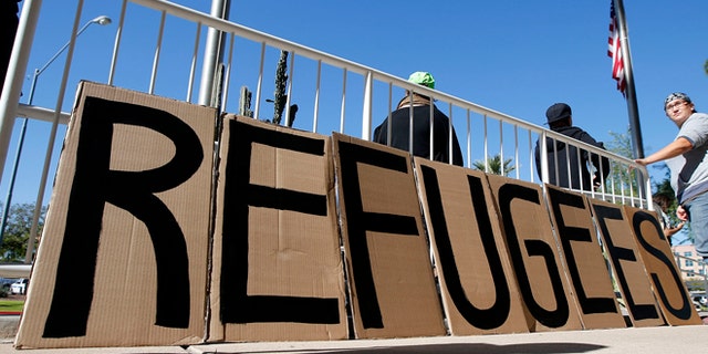 A sign welcoming Syrian refugees is placed at the entrance to the office of the Arizona governor during a rally at the Arizona Capitol.