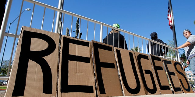 A sign welcoming Syrian refugees is placed at the entrance to the office of the Arizona governor during a rally at the Arizona Capitol.