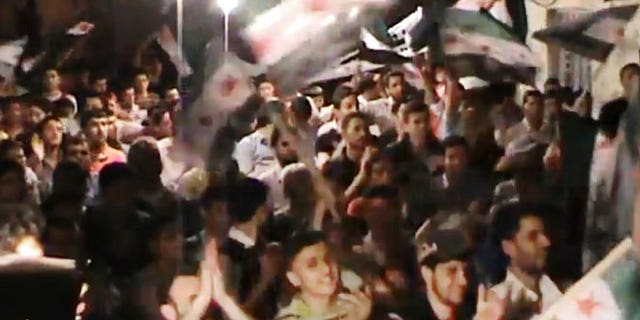 This image made from amateur video and released by the Syria media center Tuesday, May 1, 2012, purports to show Syrians chanting slogans during a demonstration in Aleppo, Syria.