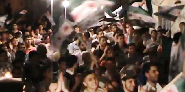 This image made from amateur video and released by the Syria media center Tuesday, May 1, 2012, purports to show Syrians chanting slogans during a demonstration in Aleppo, Syria.