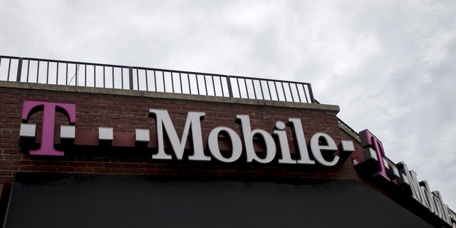 File photo - People pass by a T-Mobile store in the Brooklyn borough of New York June 4, 2015.