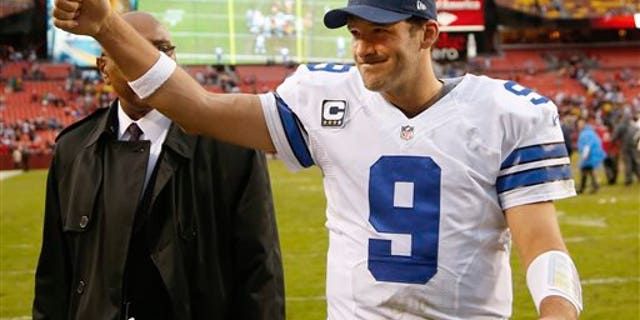 Dallas Cowboys quarterback Tony Romo flashes a thumbs-up as he walks off the field after the Cowboys defeated the Washington Redsksins 24-23 in an NFL football game in Landover, Md., Sunday, Dec. 22, 2013. (AP Photo/Evan Vucci)