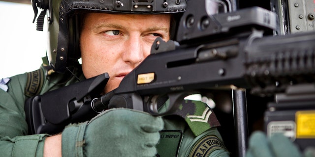 July 13, 2012: In this photo released by the British MOD, a sniper with Royal Air Force Regiment Sniper, sights through his scope from inside an RAF Puma helicopter at RAF Northolt ahead of carrying out air security duties for Op Olympic, in London.