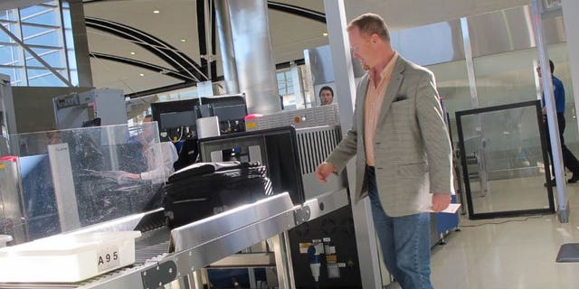 October 4: Mark Daly of Novi, Michigan, passes through the new expedited screening line at Detroit Metro Airport in its first hours of operation.