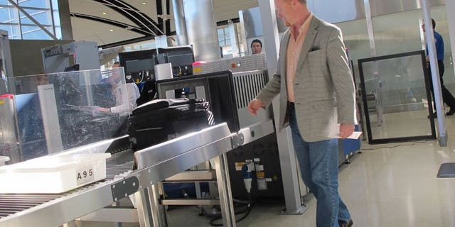 October 4: Mark Daly of Novi, Michigan, passes through the new expedited screening line at Detroit Metro Airport in its first hours of operation.