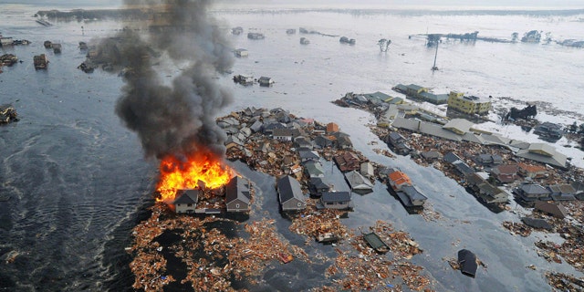March 11: Houses swallowed by tsunami waves burn in Sendai, Miyagi Prefecture (state) after Japan was struck by a strong earthquake off its northeastern coast.