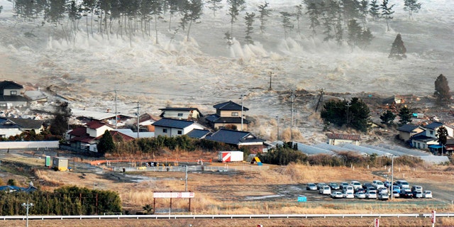 March 11: Waves of tsunami hit residences after a powerful earthquake in Natori, Miyagi prefecture.