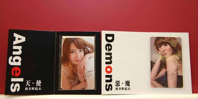 In this photo taken on Aug. 26, 2015, by the Central News Agency, two special edition swipe cards for Taiwan's mass transit are seen on display featuring the clothed image of 27-year-old, Japanese porn star Yui Hatano, in Taipei, Taiwan. Despite strong opposition, the 15,000 limited-edition cards sold out within hours overnight via a telephone hotline. (Central News Agency via the AP)