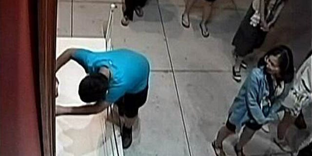Aug. 23, 2015: In this image taken from security video, an unidentified 12-year-old boy trips and falls, damaging a 17th century Italian painting at an exhibition in Taipei, Taiwan. (Huashan 1914 Creative Park)