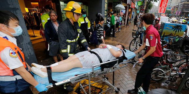 May 21, 2014: Paramedics remove a victim from a subway station exit after a knife attack on a subway in Taipei, Taiwan. (AP)