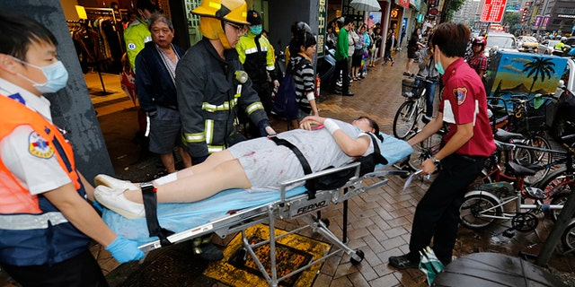 May 21, 2014: Paramedics remove a victim from a subway station exit after a knife attack on a subway in Taipei, Taiwan. (AP)