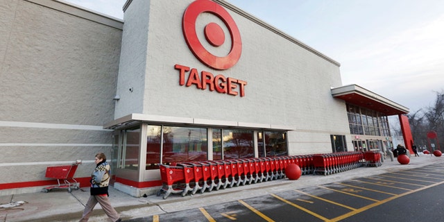 FILE - In this Dec. 19, 2013, file photo, a passer-by walks near an entrance to a Target retail store in Watertown, Mass. The security breach that hit Target Corp. during the crucial holiday season seemed to be part of a broader and highly sophisticated scam that affected several retailers, says a report published by a global cyber intelligence firm that works with the U.S. Secret Service and the Department of Homeland Security, Thursday, Jan. 16, 2014. (AP Photo/Steven Senne, File)