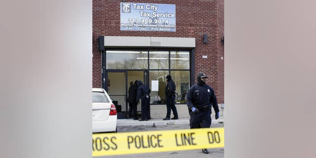 Detroit Police Officers check out the scene after a shooting injuring four people at a tax preparation business in Detroit, Friday, Feb. 28, 2014. Deputy Police Chief Rodney Johnson said a woman became upset when her tax refund wasn't ready Friday and started scuffling with the guard. Johnson said the man with her pulled a gun and started shooting. (AP Photo/Detroit Free Press, Jarrad Henderson) DETROIT NEWS OUT; NO SALES; MANDATORY CREDIT
