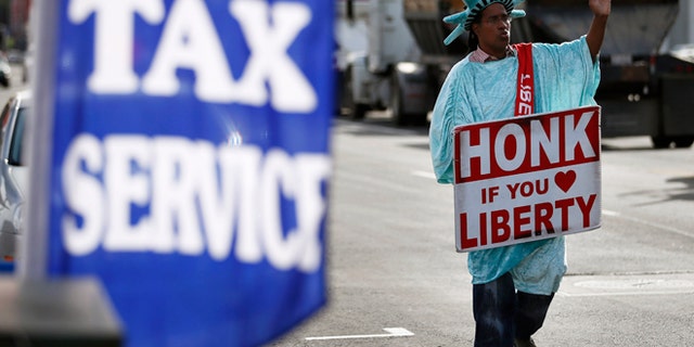 Jan. 22, 2013: Dressed as the Statue of Liberty, part-time employee, Zidkijah Zabad, waves to passing motorists while holding a sign to advertise for Liberty Tax Service in Los Angeles.