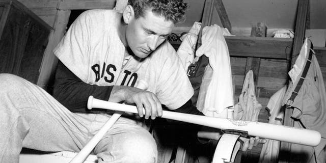 March 16, 1948: In this file photo, Boston Red Sox Ted Williams weighs one of his new 36-ounce Hickory baseball bats in the clubhouse after morning workout at spring training in Sarasota, Fla.