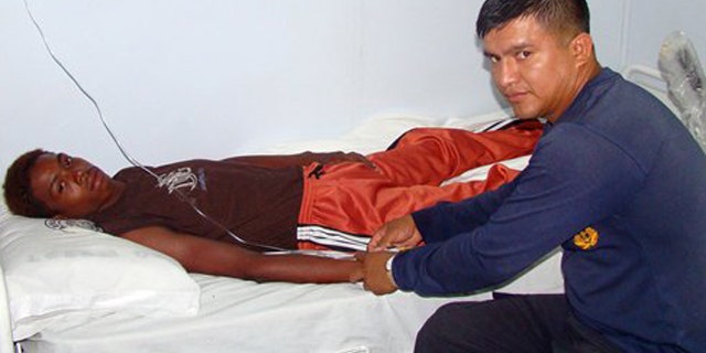 Mar. 26, 2012: Adrian Vasquez, left, an 18-year-old Panamanian who worked as a maid in a seaside resort hotel, receives medical attention aboard an Ecuadorean navy ship offshore Galapagos Islands, Ecuador.