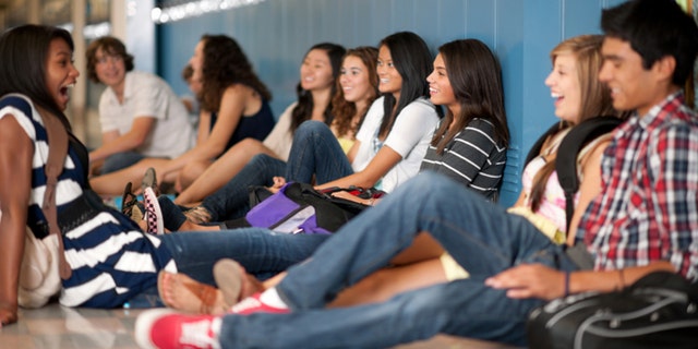 Highschool friends hanging out in the hallway.