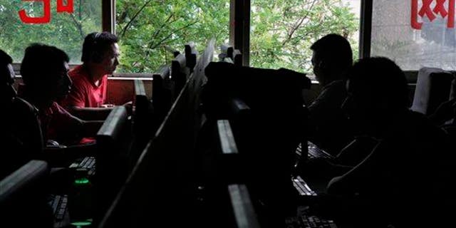 Chinese computer users sits in front of computer terminals at an Internet cafe in Beijing, China, Wednesday, July 14, 2010.