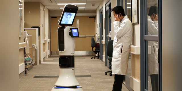 Dr. Alan Shatzel, medical director of the Mercy Telehealth Network, is displayed on the monitor RP-VITA robot as he waits to confer with Dr. Alex Nee at Mercy San Juan Hospital in Carmichael, Calif. (AP Photo/Rich Pedroncelli)