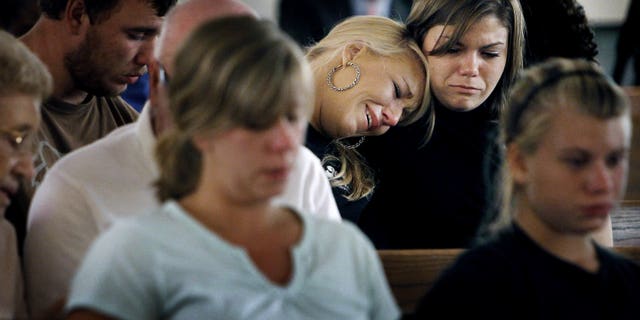 August 10: Sisters Brittany (left) and Kristen Bridges, both former students at Memphis Junior Academy, weep during an impromptu prayer vigil for slain principal Suzette York, who was killed in one of the school's classrooms in Memphis, Tennessee. The vigil held at Mullins United Methodist Church was attended by several former students and York family friends. Eduardo Marmolejo, a 17-year-old male student, has been charged with York's murder.