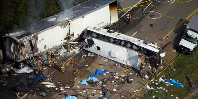 Emergency workers respond to a crash involving a passenger bus and a tractor-trailer near Dandridge, Tenn., on Wednesday, Oct. 2, 2013.