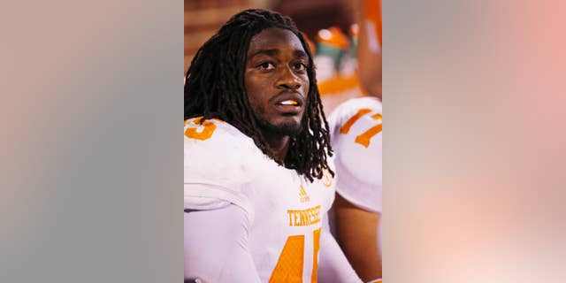 FILE - In this Sept. 13, 2014, file photo,Tennessee linebacker A.J. Johnson sits on the bench during an NCAA college football game between Tennessee and Oklahoma in Norman, Okla. Tennessee has suspended leading tackler Johnson and defensive back Michael Williams amid a sexual assault investigation. The school announced Monday, Nov. 17 on the football program’s Twitter account that both players had been suspended “from all team-related activities” without going into further details. (AP Photo/Sue Ogrocki, File)