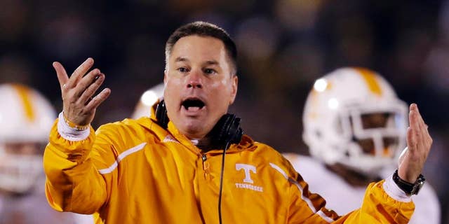 FILE - In this Nov. 2, 2013, file photo, Tennessee head coach Butch Jones yells on the sidelines during the first half of an NCAA college football game against Missouri in Columbia, Mo. Jones discusses the opening of a spring practice that features a four-way quarterback competition and the arrival of 14 early enrollees. The Volunteers hold their first spring workout Friday, March 7, 2014. (AP Photo/Jeff Roberson, File)