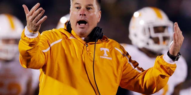 FILE - In this Nov. 2, 2013, file photo, Tennessee head coach Butch Jones yells on the sidelines during the first half of an NCAA college football game against Missouri in Columbia, Mo. Jones discusses the opening of a spring practice that features a four-way quarterback competition and the arrival of 14 early enrollees. The Volunteers hold their first spring workout Friday, March 7, 2014. (AP Photo/Jeff Roberson, File)