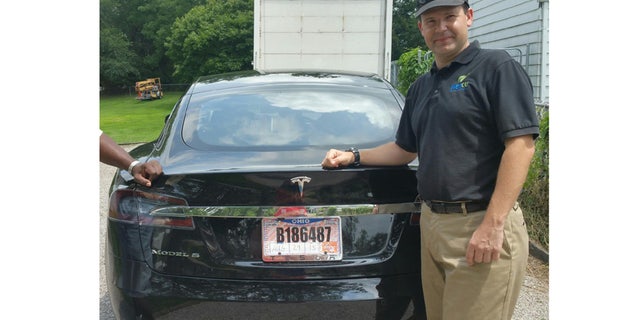 FILE - In this 2015 file photo provided by his neighbor, Krista Kitchen, Joshua Brown stands by his new Tesla electric car near his home in Canton, Ohio. (Krista Kitchen via AP, File)