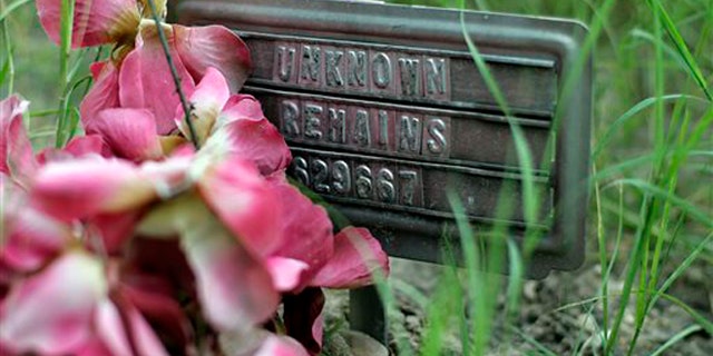 In this Aug. 23, 2013, photo, a small sign at a cemetery marks the grave site of an unidentified body found on a ranch, in Falfurrias, Texas. Brooks County, home to a Border Patrol checkpoint about an hour north of the border, handled 129 bodies last year of immigrants that died in their attempt to come to the U.S. Brooks County is now trying to improve its services by performing an autopsy on all immigrants and making greater efforts to identify them. (AP Photo/Eric Gay)