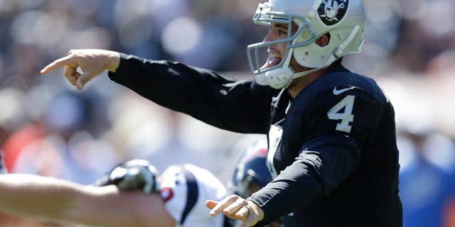 Houston Texans running back Arian Foster, left, carries the ball past Oakland Raiders outside linebacker Sio Moore in the first quarter of an NFL football game Sunday, Sept. 14, 2014, in Oakland, Calif. (AP Photo/Ben Margot)