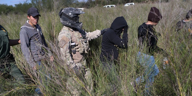 A Border Patrol agent leads undocumented immigrants on December 7, 2015 near Rio Grande City, Texas.