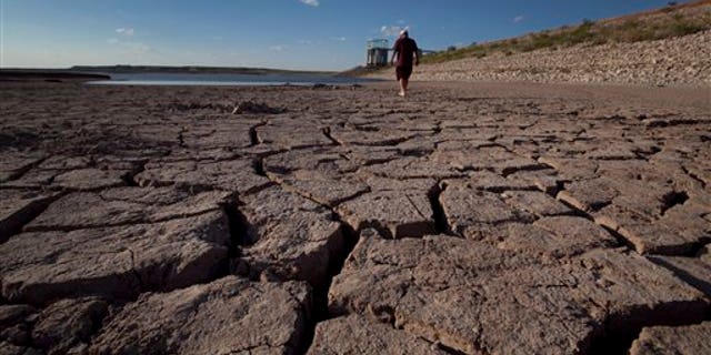 August 7: Eddie Ray Roberts, superintendent of the city's waste and water department walking on the dried bed of Lake E.V. Spence in Robert Lee, Texas.