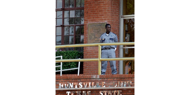 FILE - In this Sept. 21, 2011, file photo, a corrections officer keeps watch outside the Texas Department of Criminal Justice Huntsville Unit in Huntsville, Texas.  (AP Photo/David J. Phillip, File)