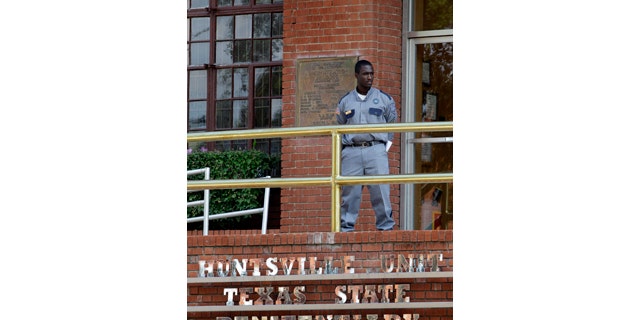 FILE - In this Sept. 21, 2011, file photo, a corrections officer keeps watch outside the Texas Department of Criminal Justice Huntsville Unit in Huntsville, Texas. (AP Photo/David J. Phillip, File)