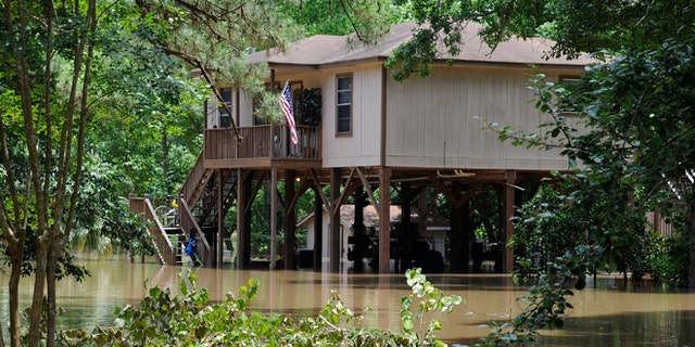 A house built on tall piers is surrounded by flood water from the San Jacinto River Thursday, May 28, 2015, in Kingwood, Texas. Although the deadly thunderstorms that lashed much of Texas have tapered off, many cities were still in danger of flooding Thursday as heavy rain from earlier in the week poured downstream, swelling rivers. (AP Photo/Pat Sullivan)