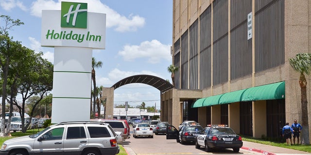 June 19, 2012: A line of Laredo Police Department vehicles line the entrance to the Holiday Inn Civic Center in Laredo, Texas, where two young boys were shot.