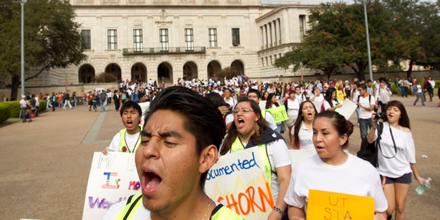 University of Texas student Jonathan Hernandez, 21, marches in an immigration rights rally on the University of Texas campus in Austin, Texas, Wednesday Nov. 20, 2013. The rally was organized in reaction to the student group Young Conservatives of Texas "Catch an Illegal Immigrant Game" that was canceled due to public outrage. (AP Photo/Austin American-Statesman, Jay Janner) AUSTIN CHRONICLE OUT, COMMUNITY IMPACT OUT, MAGS OUT; INTERNET AND TV MUST CREDIT PHOTOGRAPHER AND STATESMAN.COM