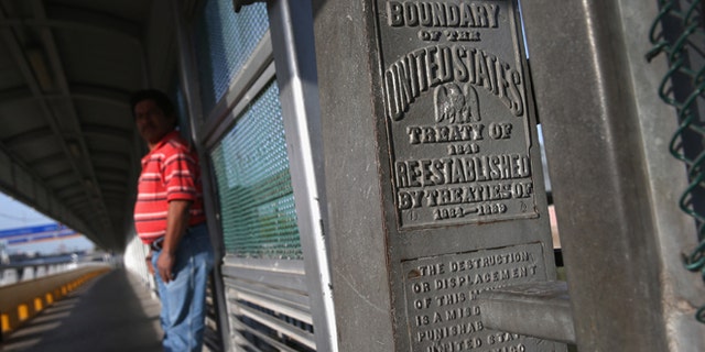 A marker over the Rio Grande River notes the border between the United States and Mexico (L), on April 11, 2013 in Hidalgo, Texas. A(Photo by John Moore/Getty Images)